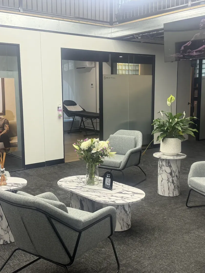 SOUL IV clinic waiting lounge with grey armchairs, marble side tables and fresh flowers