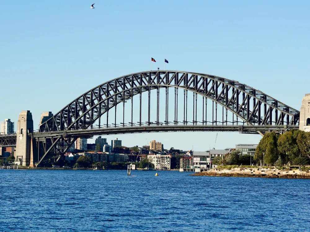 The Sydney Harbour Bridge spanning the harbour under a clear blue sky